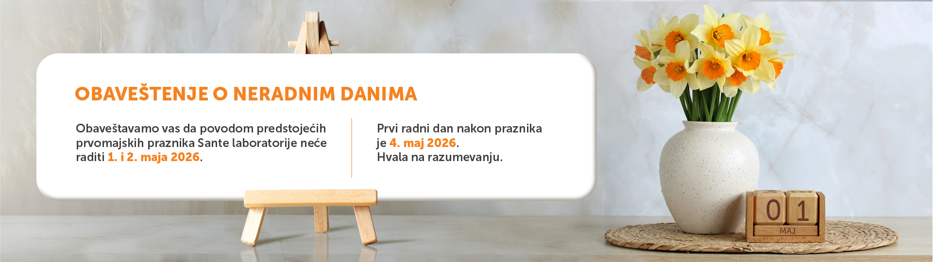 Announcement banner about upcoming non-working days with dates, on a desk backdrop featuring a vase of yellow flowers and a wooden calendar showing 01 MAJ (May).