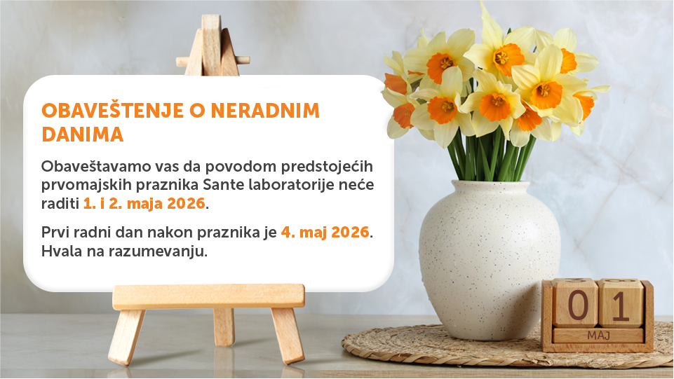 Announcement card on a wooden easel: notice about non-working days with dates 1–2 May 2026, against a vase of yellow daffodils.